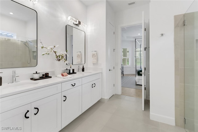 bathroom with tile patterned flooring, vanity, and tiled shower