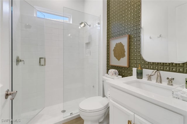 bathroom featuring a shower, vanity, and toilet