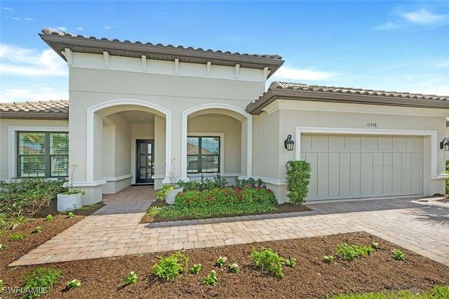 mediterranean / spanish-style home featuring covered porch and a garage