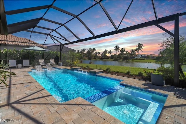 pool at dusk with a lanai, pool water feature, a patio area, an in ground hot tub, and a water view