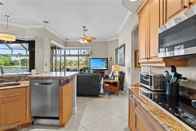 kitchen with ceiling fan with notable chandelier, stainless steel appliances, crown molding, light tile patterned floors, and a water view