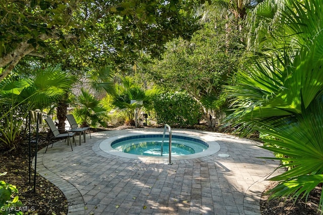 view of swimming pool featuring a patio area and an in ground hot tub