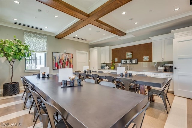 dining space with light hardwood / wood-style flooring, ornamental molding, beamed ceiling, and coffered ceiling