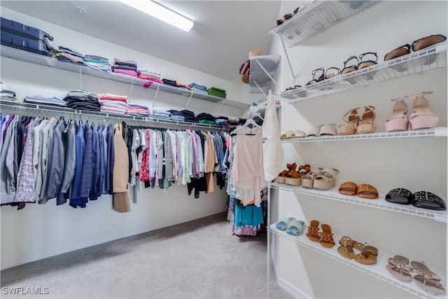 walk in closet with light carpet