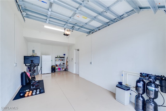 garage with a garage door opener and white fridge