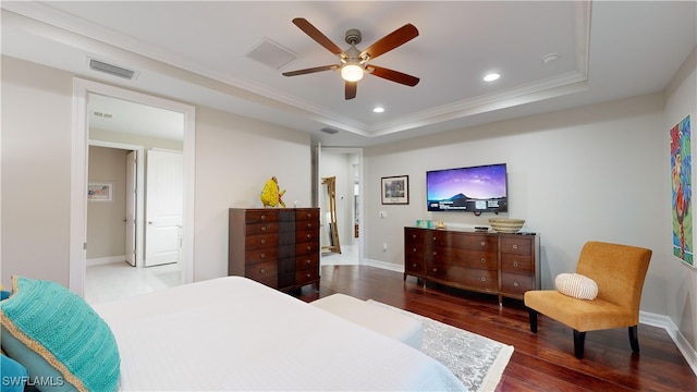 bedroom with wood-type flooring, a tray ceiling, ceiling fan, and crown molding