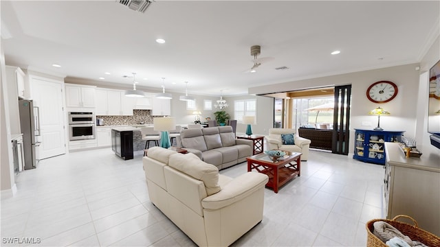 living room featuring crown molding, ceiling fan, and light tile patterned floors