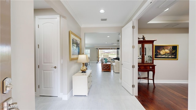 hallway with crown molding and light hardwood / wood-style flooring