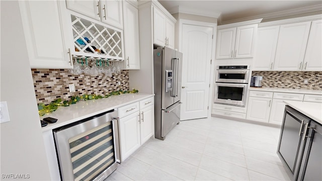 kitchen with white cabinets, appliances with stainless steel finishes, and tasteful backsplash