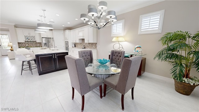 dining area featuring a wealth of natural light, crown molding, a chandelier, and sink