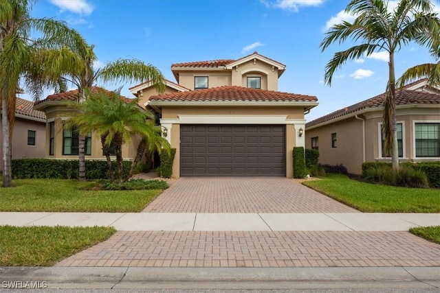 mediterranean / spanish-style house featuring a front yard and a garage