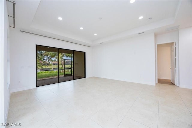 unfurnished room featuring a raised ceiling