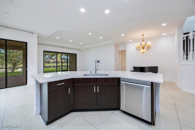 kitchen featuring dark brown cabinetry, a kitchen island with sink, sink, an inviting chandelier, and dishwasher