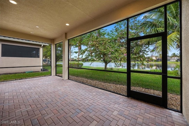 unfurnished sunroom with a water view