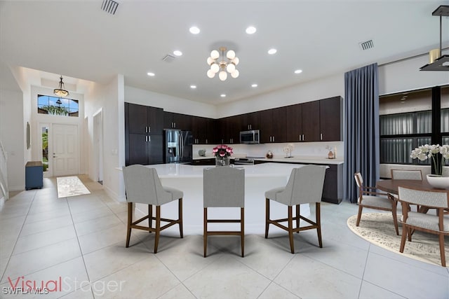 kitchen with a breakfast bar, a center island, dark brown cabinets, and stainless steel appliances