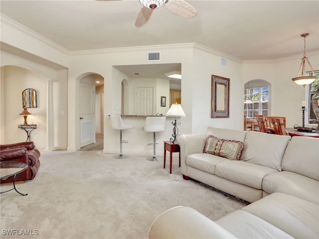 carpeted living room featuring crown molding and ceiling fan