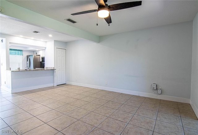 unfurnished living room featuring ceiling fan and light tile patterned flooring