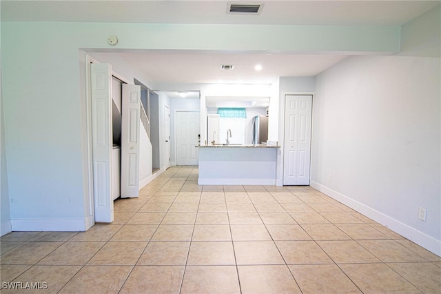 kitchen featuring sink, stainless steel refrigerator, and light tile patterned floors