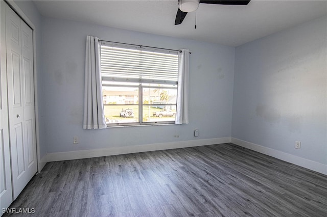 unfurnished bedroom with ceiling fan, dark wood-type flooring, and a closet