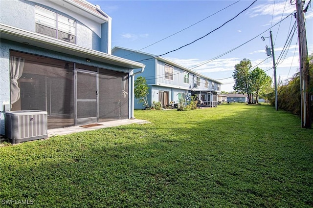 view of yard with central AC unit and a sunroom