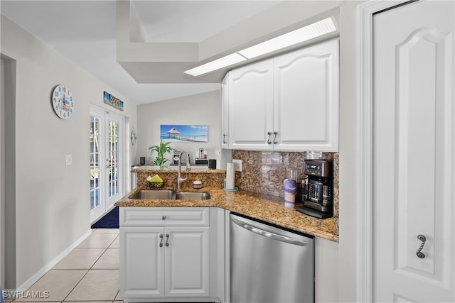 kitchen featuring kitchen peninsula, white cabinets, stainless steel dishwasher, light tile patterned flooring, and sink