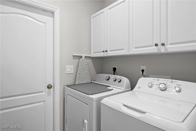 laundry area with cabinets and washer and clothes dryer