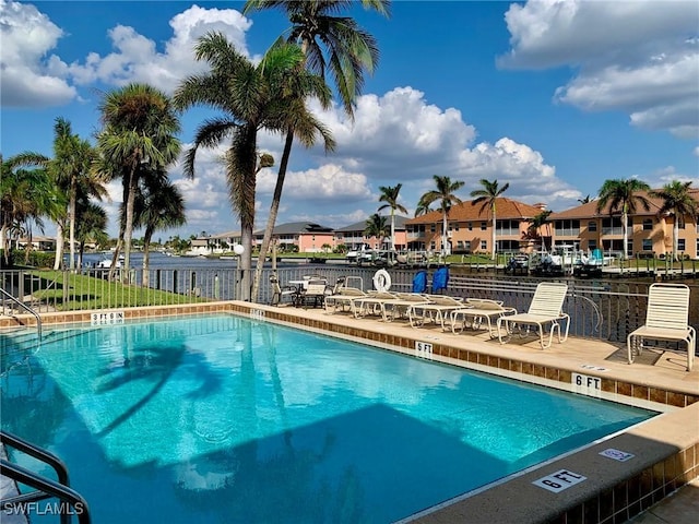 view of swimming pool featuring a patio and a water view