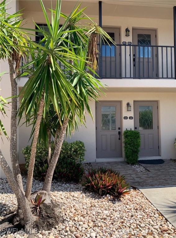 property entrance featuring stucco siding and a balcony