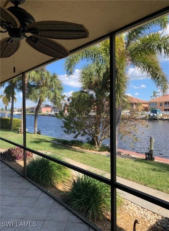 unfurnished sunroom featuring a water view and ceiling fan