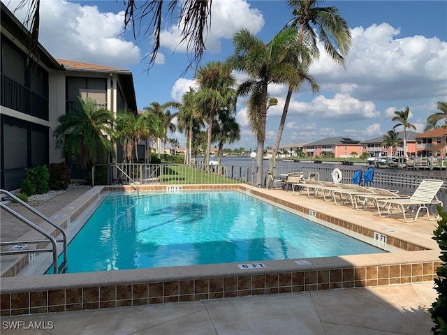 view of pool with a patio and a water view