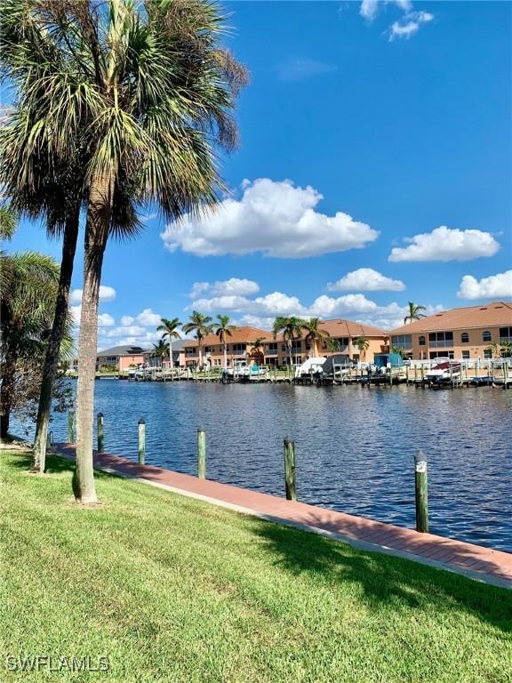 dock area with a water view and a yard