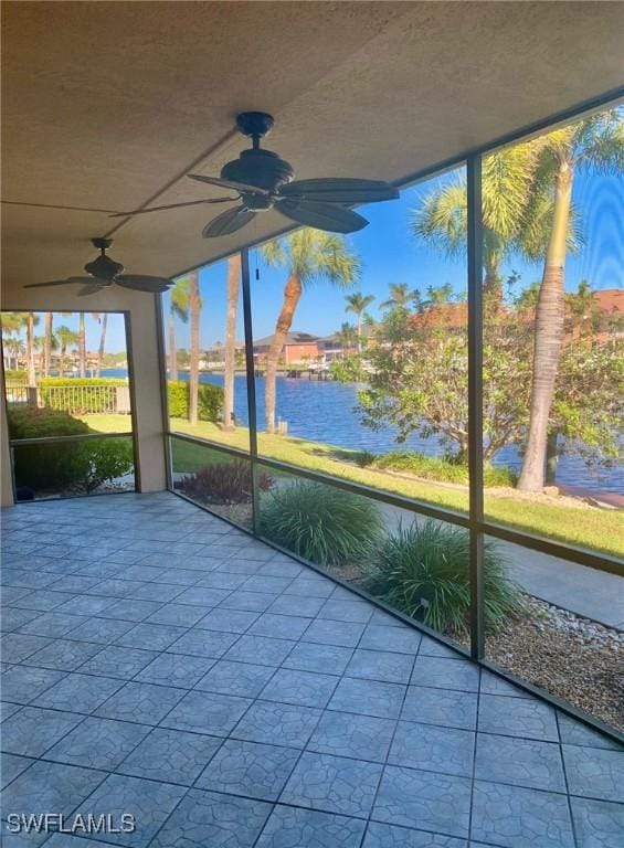 unfurnished sunroom featuring a water view