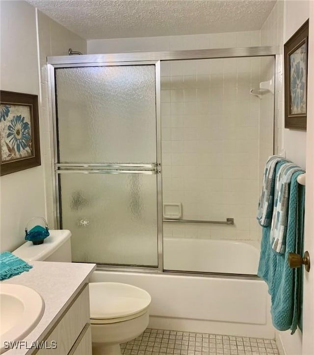 full bathroom featuring enclosed tub / shower combo, vanity, toilet, tile patterned floors, and a textured ceiling