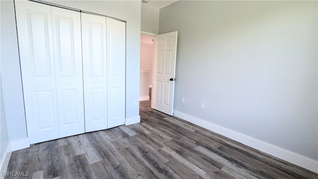 unfurnished bedroom featuring dark hardwood / wood-style flooring and a closet