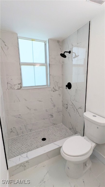 bathroom with toilet and a tile shower