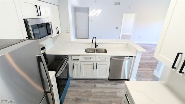 kitchen featuring white cabinets, light stone countertops, sink, and appliances with stainless steel finishes