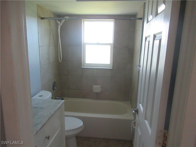 full bathroom with tiled shower / bath, vanity, and toilet