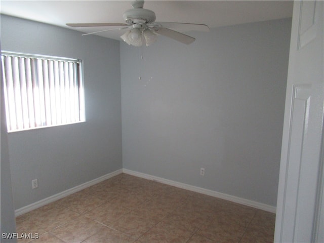 spare room with ceiling fan and light tile patterned floors