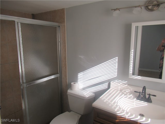 bathroom featuring vanity, toilet, and walk in shower