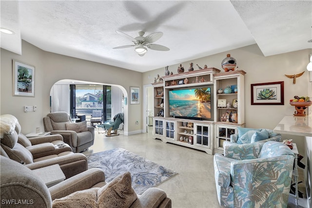 tiled living room with a textured ceiling and ceiling fan