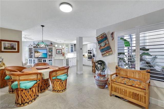 tiled dining room with a textured ceiling and sink