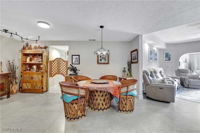 tiled dining area with a textured ceiling