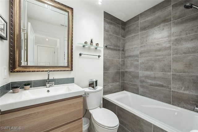 full bath featuring tiled shower / bath, vanity, and toilet