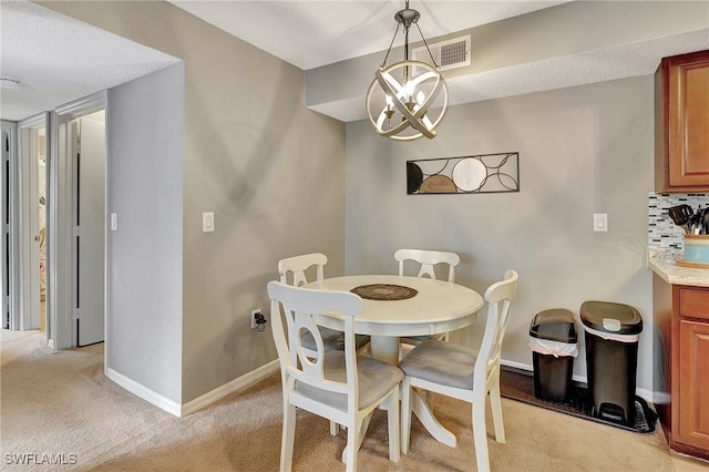 carpeted dining room with a notable chandelier