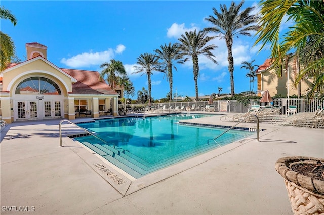 view of swimming pool with french doors and a patio area