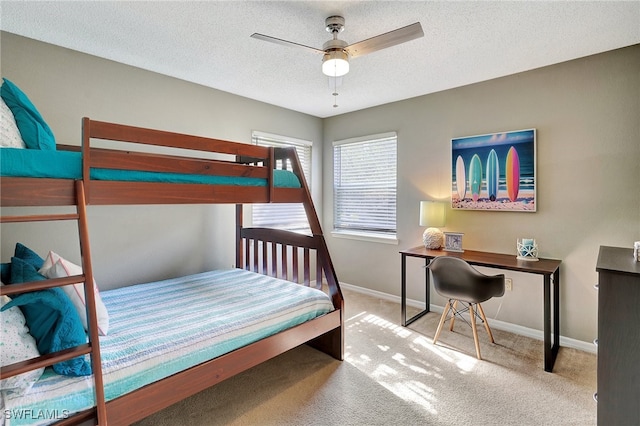 carpeted bedroom featuring ceiling fan and a textured ceiling