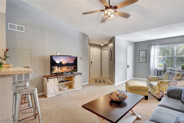 carpeted living room featuring ceiling fan and a textured ceiling