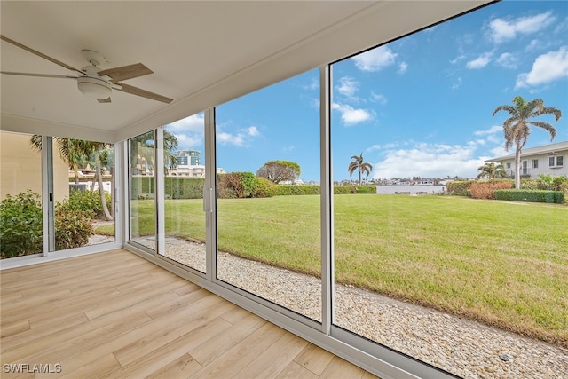 unfurnished sunroom featuring ceiling fan