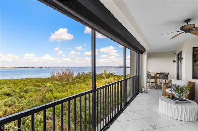 balcony featuring ceiling fan and a water view