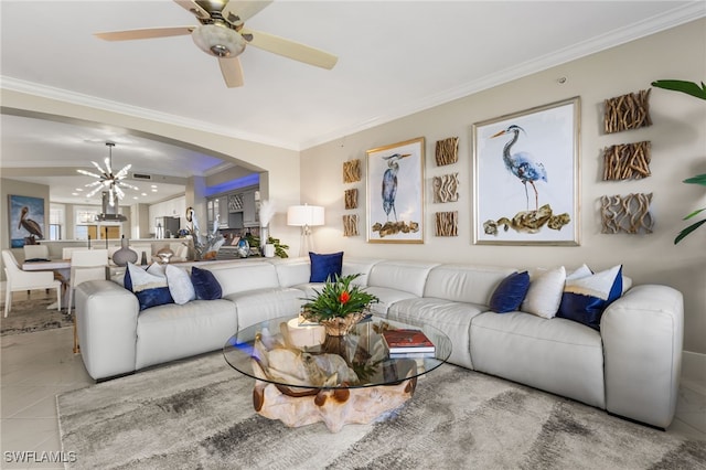 living room with ceiling fan with notable chandelier and ornamental molding